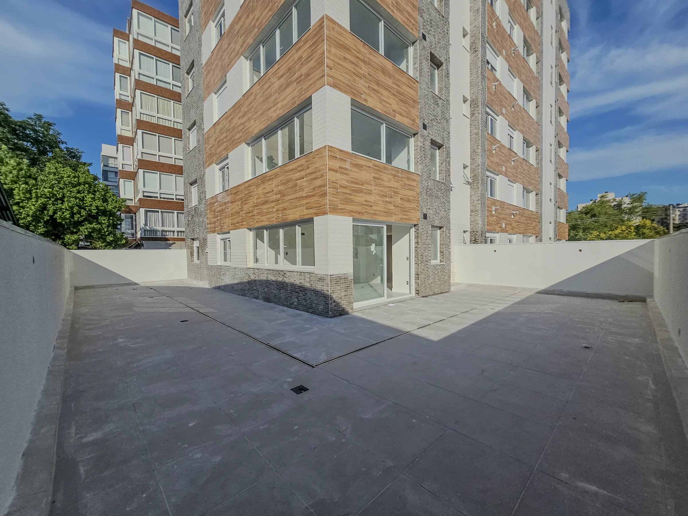 Fachada do Garden 204 com revestimento madeirado e terraço amplo